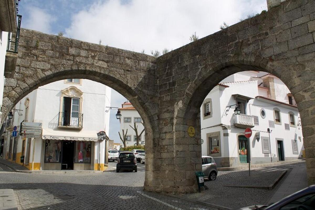 Un antiguo puente de piedra con dos arcos en una calle de la ciudad.