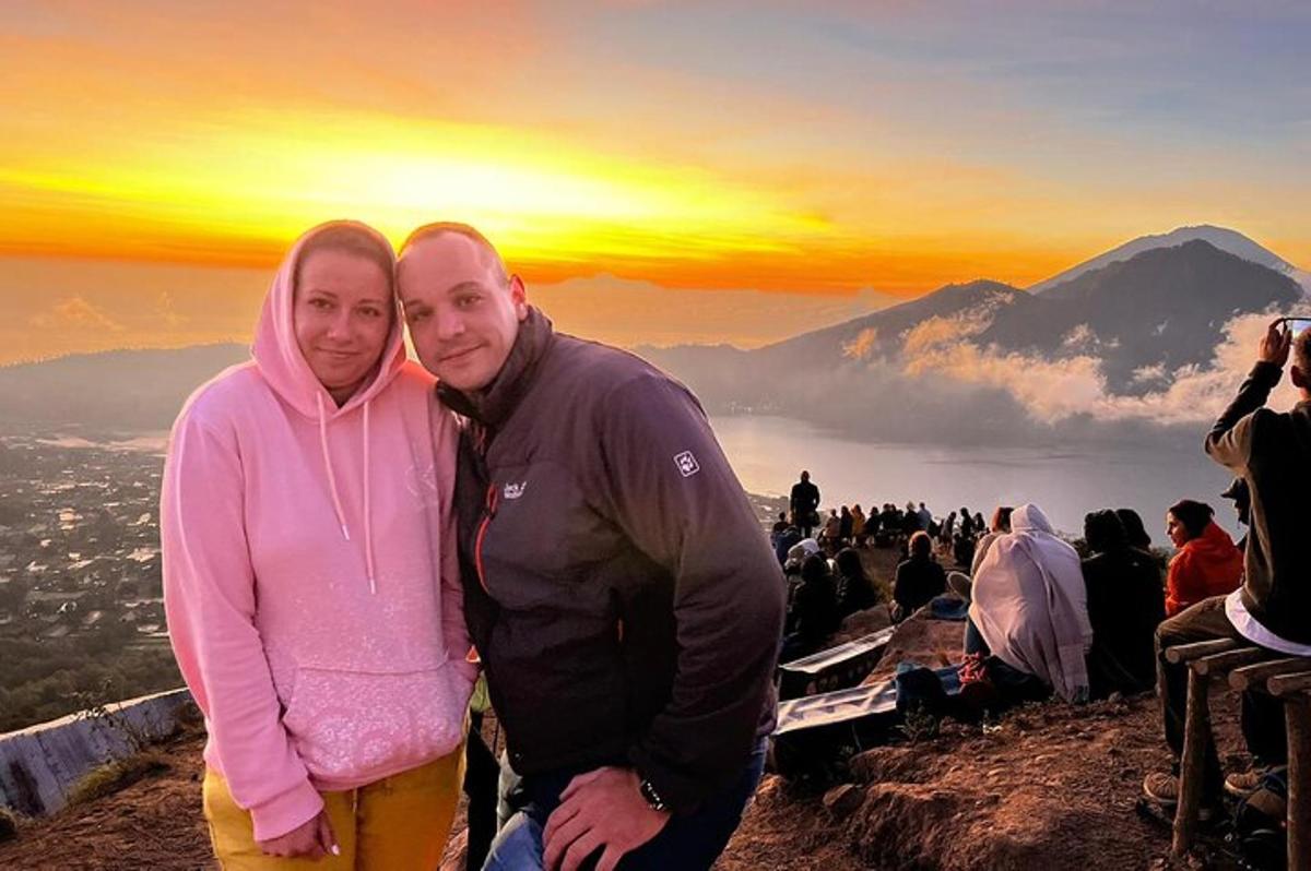 un uomo e una donna in piedi sulla cima di una montagna