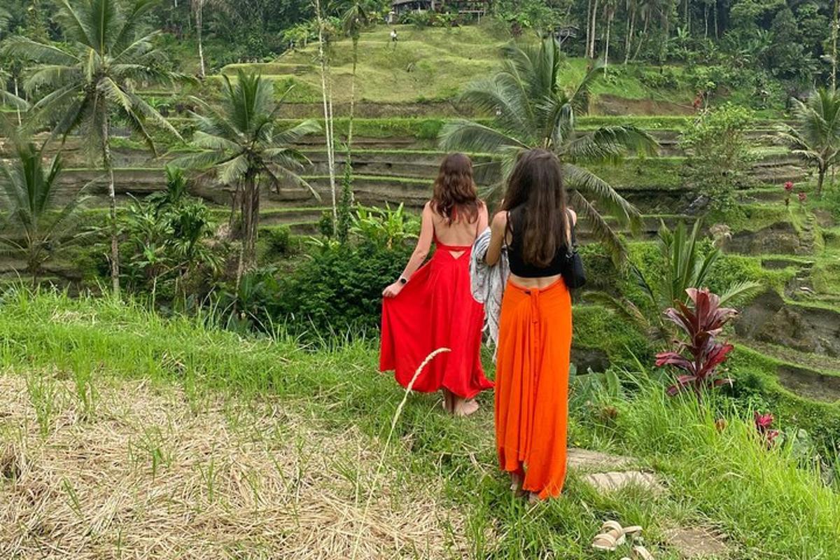 dua wanita berjalan menyusuri jalan sambil melihat sebuah bukit