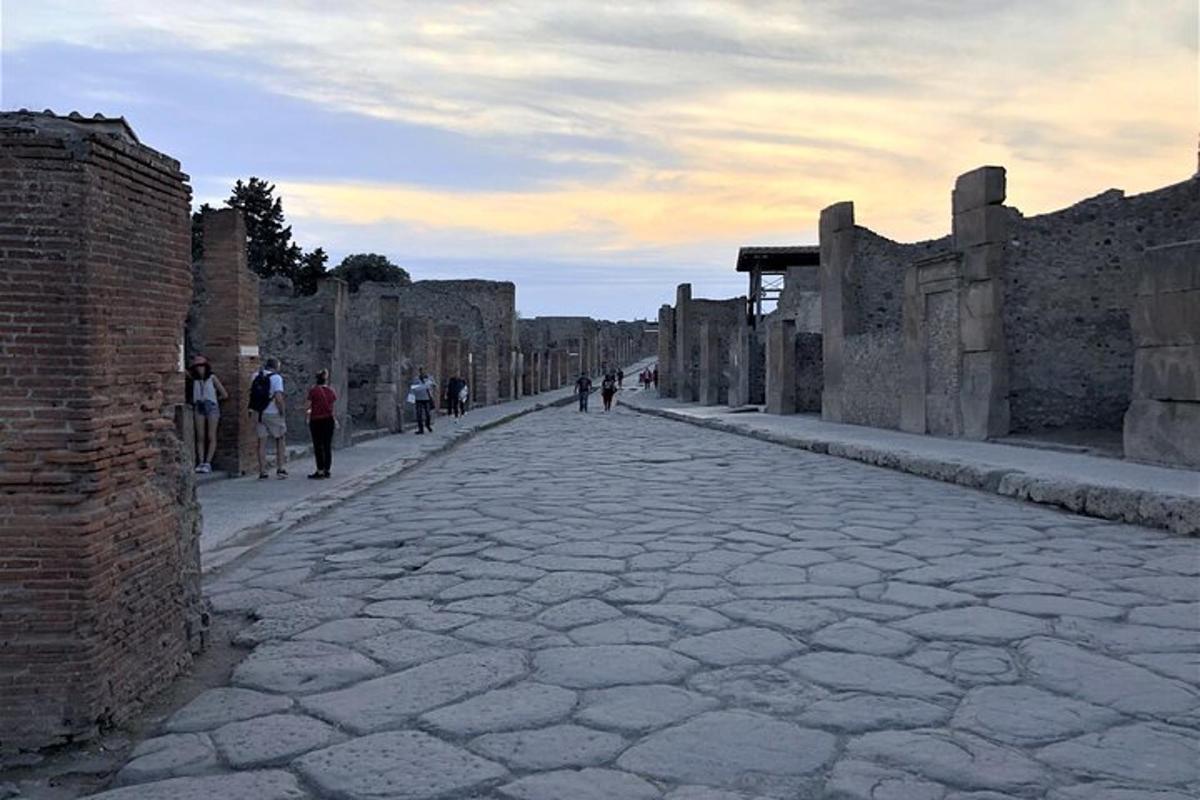 uma rua de paralelepípedos com pessoas caminhando nela