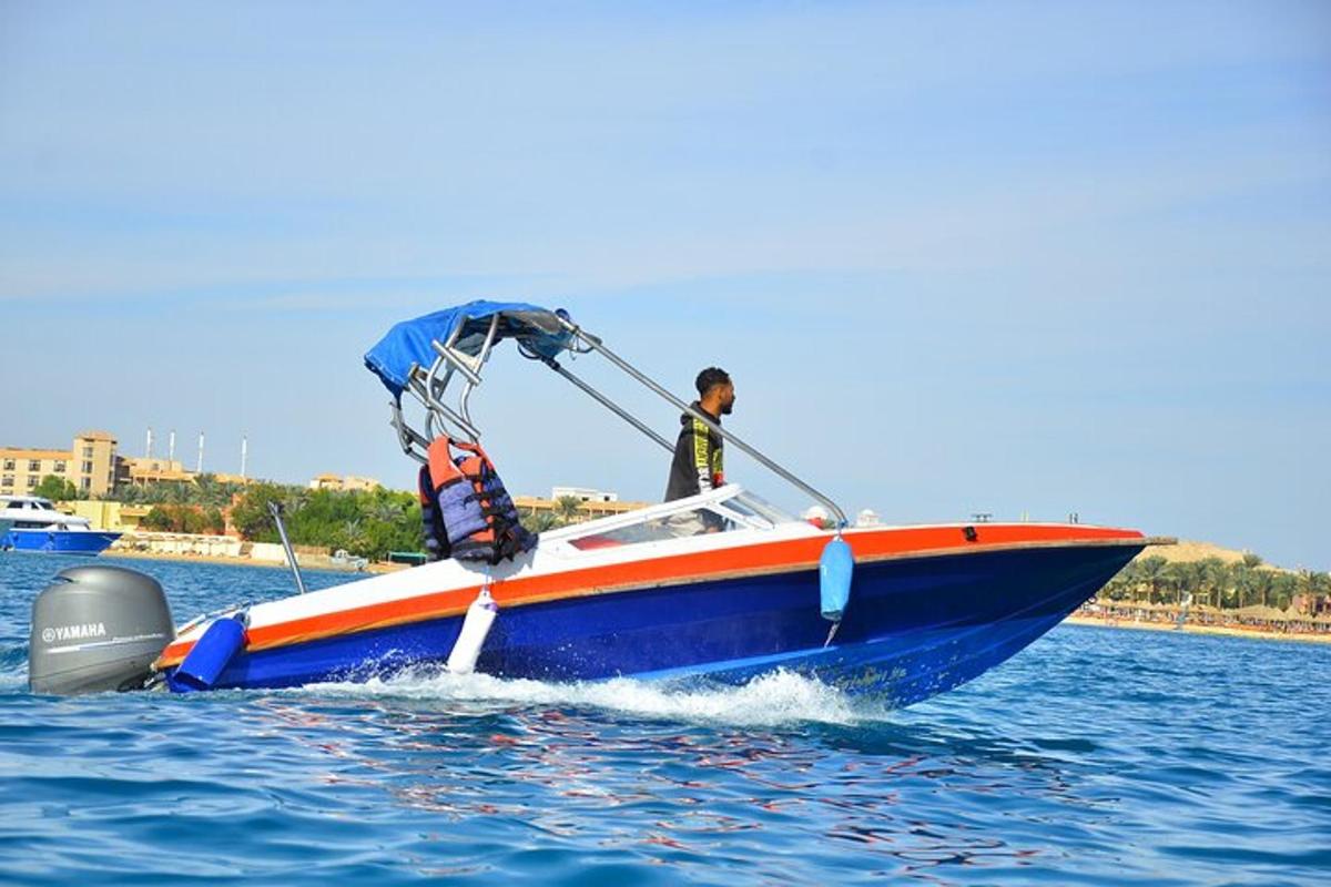 un uomo su una barca blu e arancione in acqua