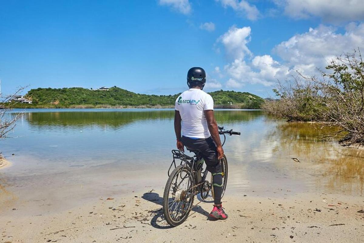 a man standing on a bike on the beach