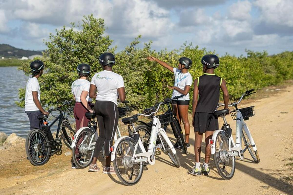a group of people standing on a beach with bikes
