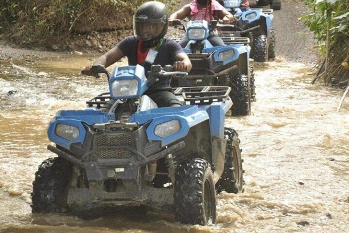 um grupo de pessoas andando de quadriciclo por uma estrada de terra