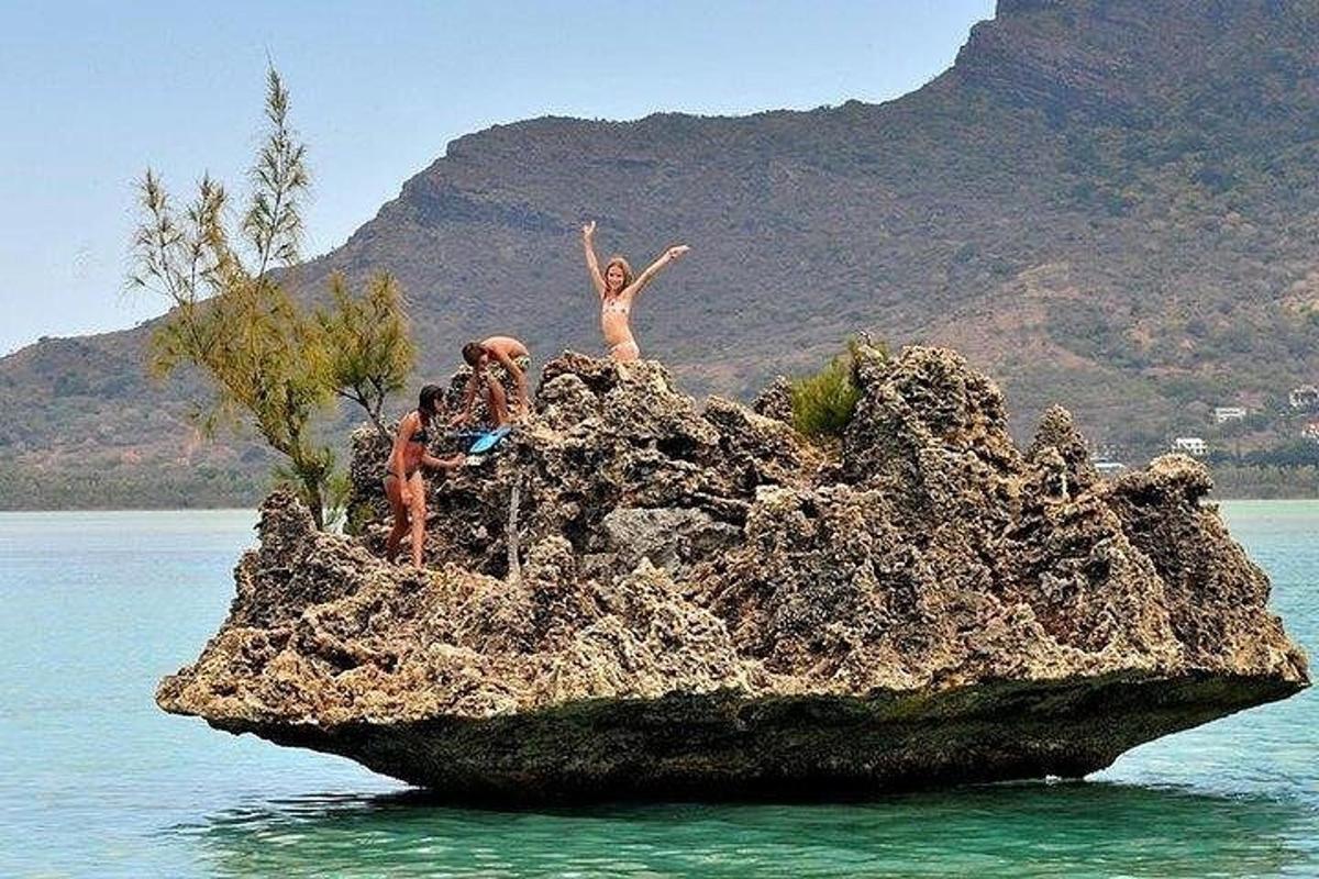 Un grupo de personas en una roca en el agua.