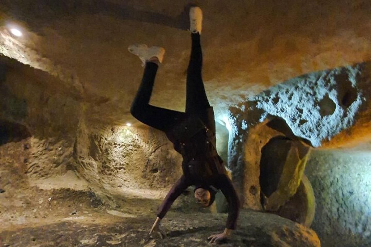 moški dela stojko na rokah v jami