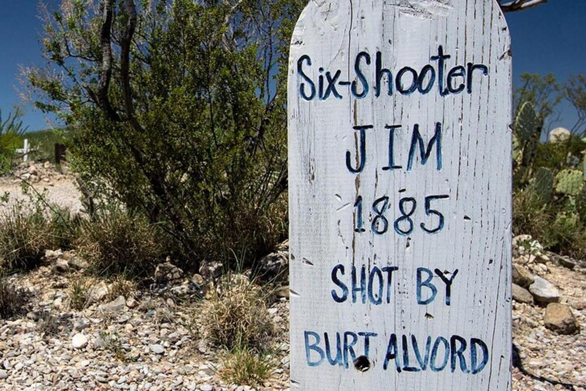 a wooden sign with writing on it next to a bush