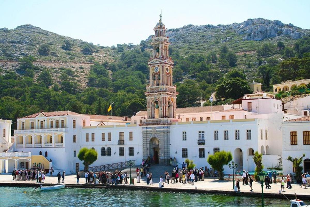 un edificio con una torre dell'orologio di fronte a una montagna