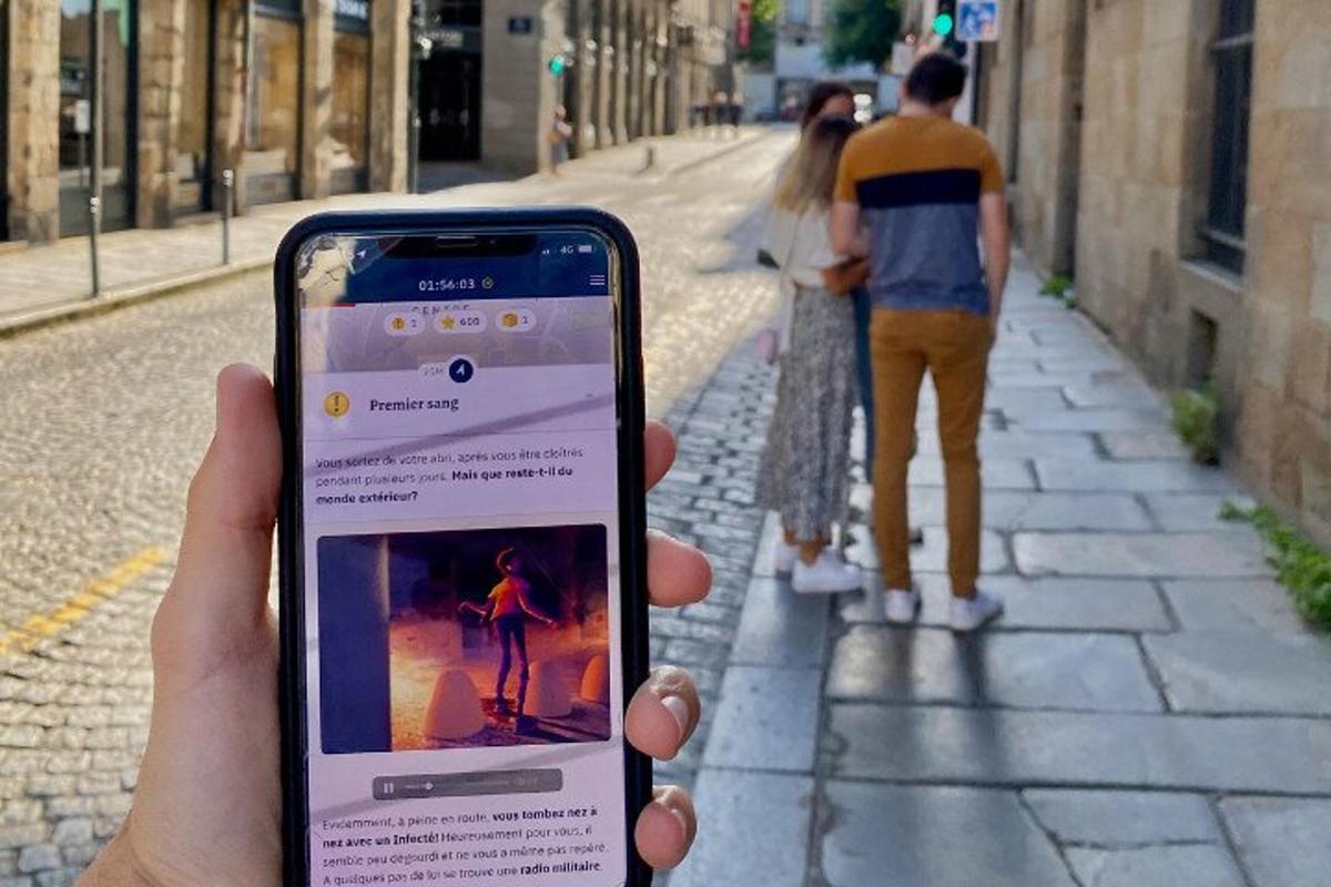una persona que sosté un telèfon mòbil al carrer