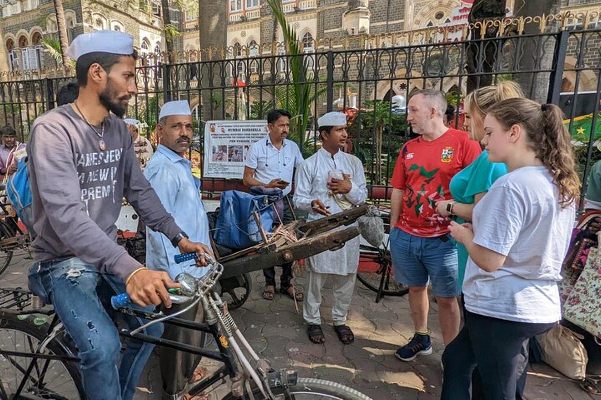 a group of people standing around a man on a bike