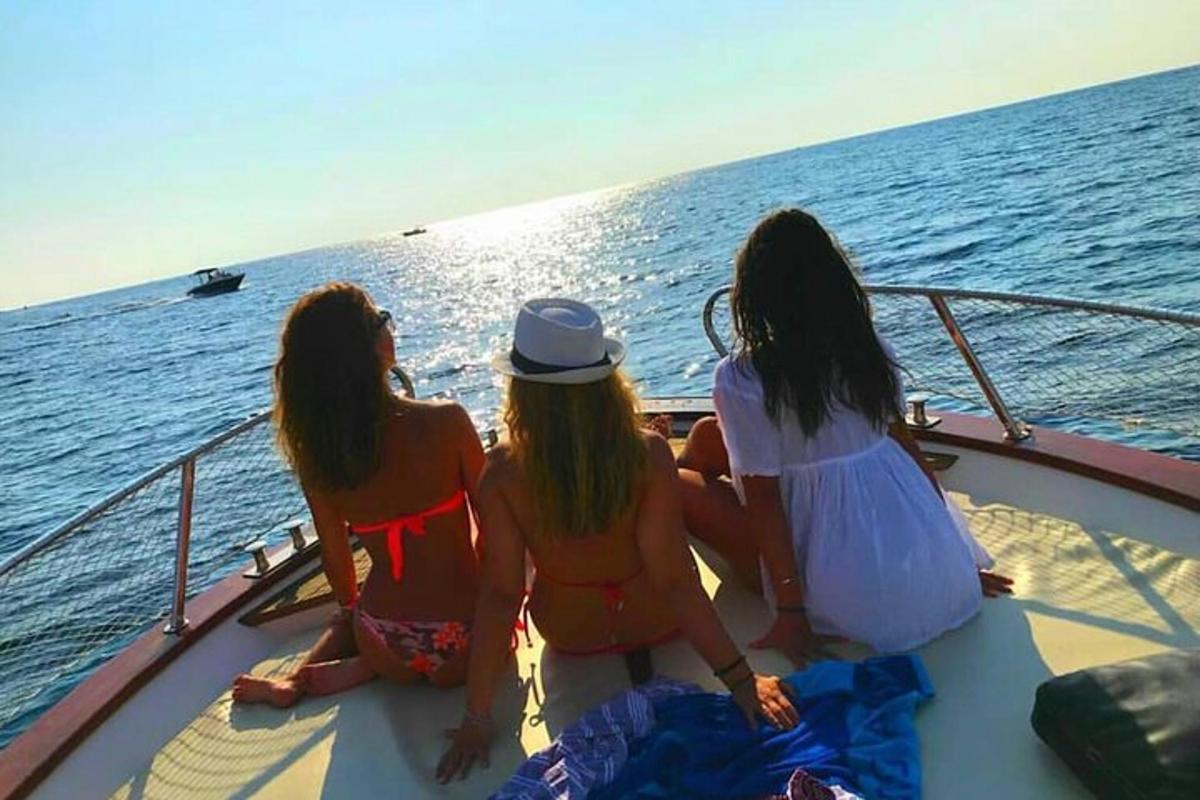 three girls sitting on a boat in the ocean