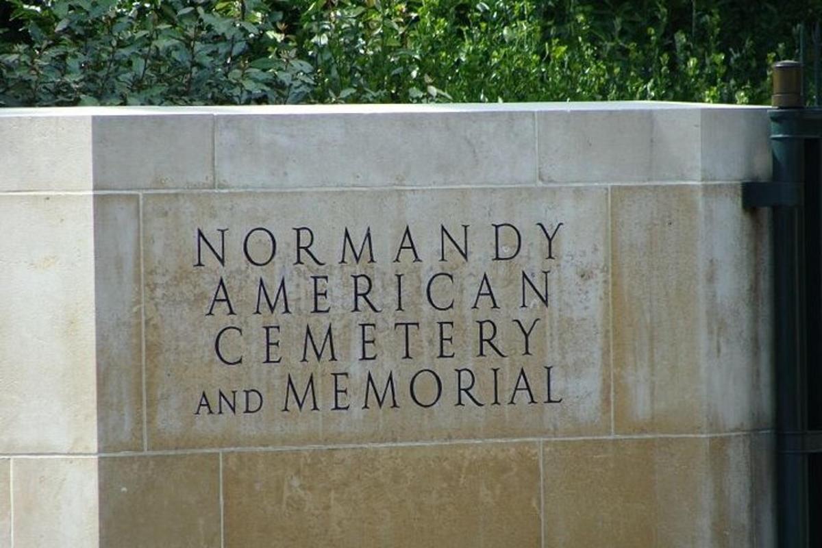 a sign for a american cemetery and memorial