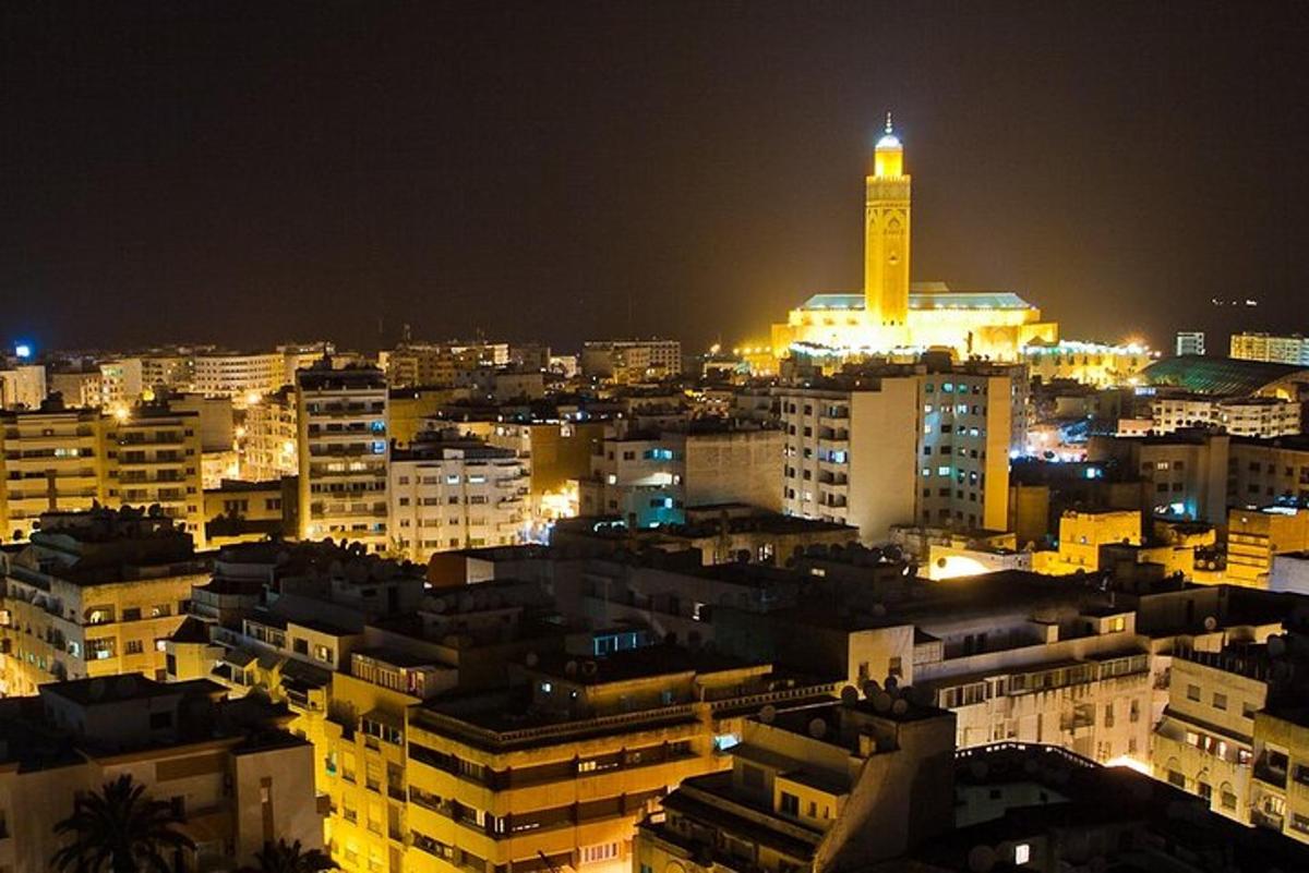 a city lit up at night with a clock tower