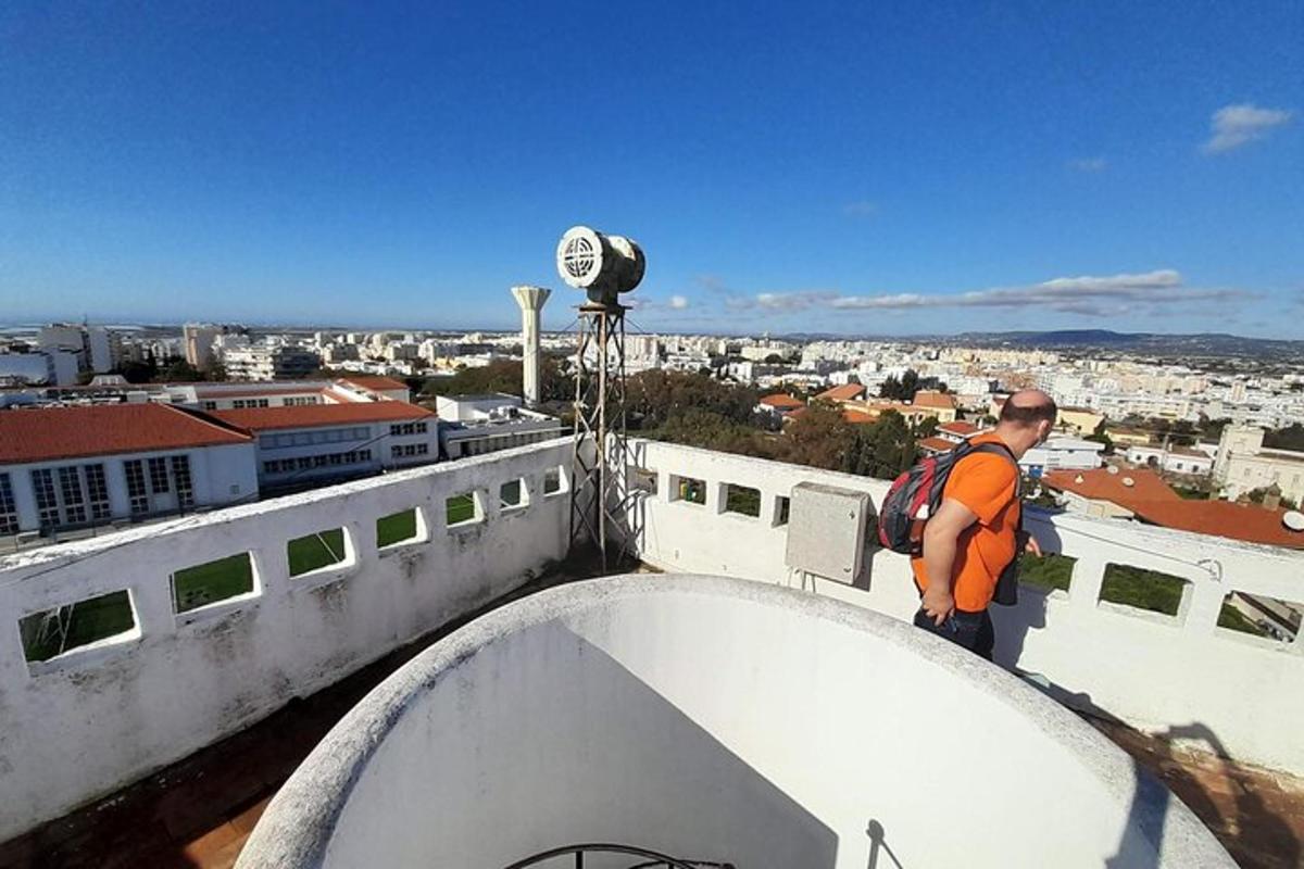 un uomo con uno zaino in piedi in cima a un edificio