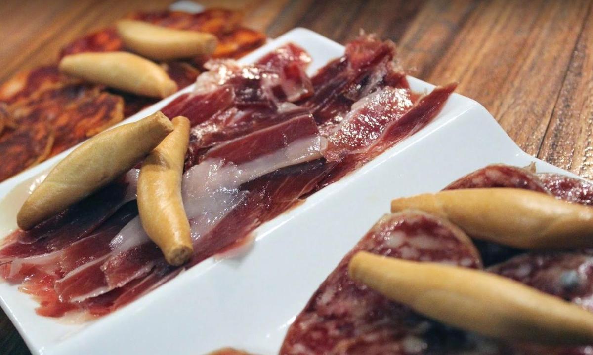 bel krožnik hrane s hrenovkami in kumaricami