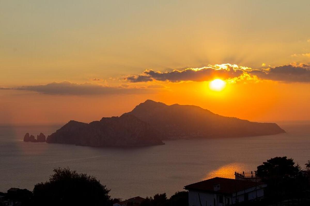 un tramonto sull'oceano con una montagna