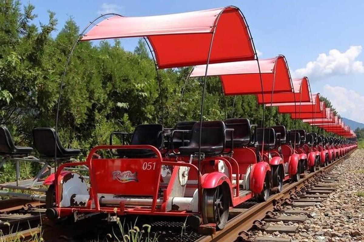 a red train with black seats on the tracks