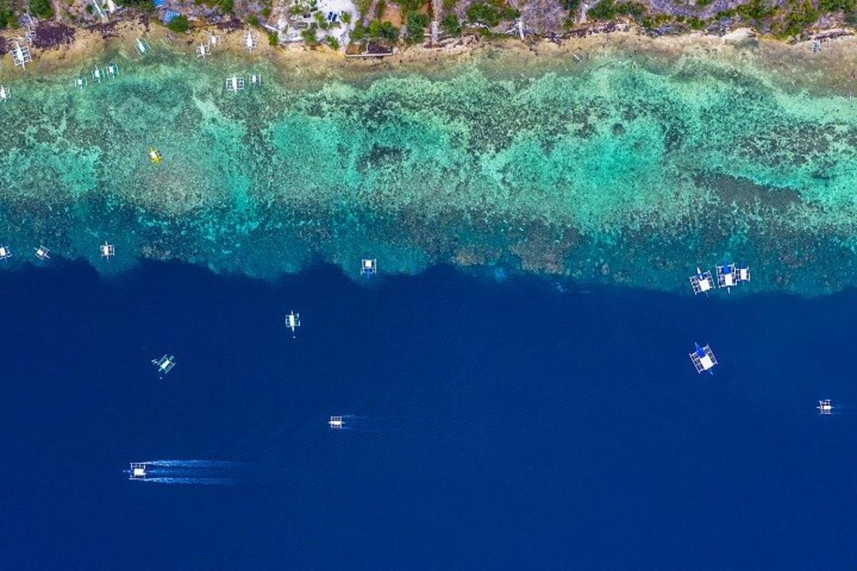 an aerial view of the ocean with boats in the water