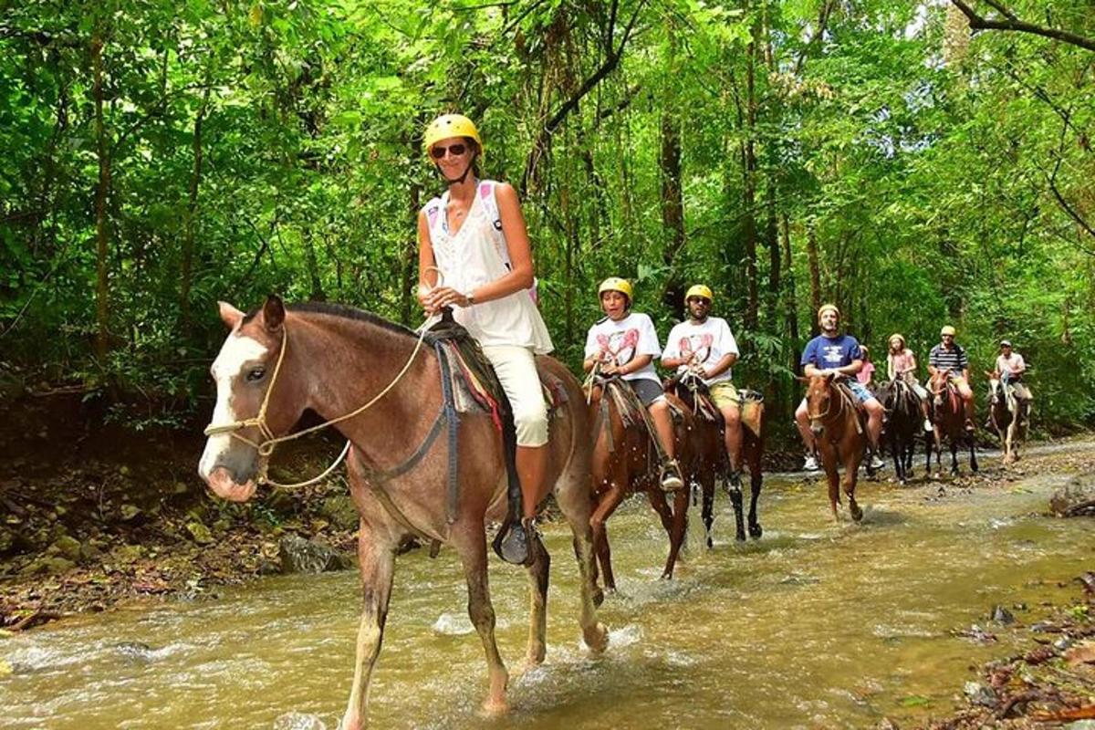Un grupo de personas montando a caballo por un río.