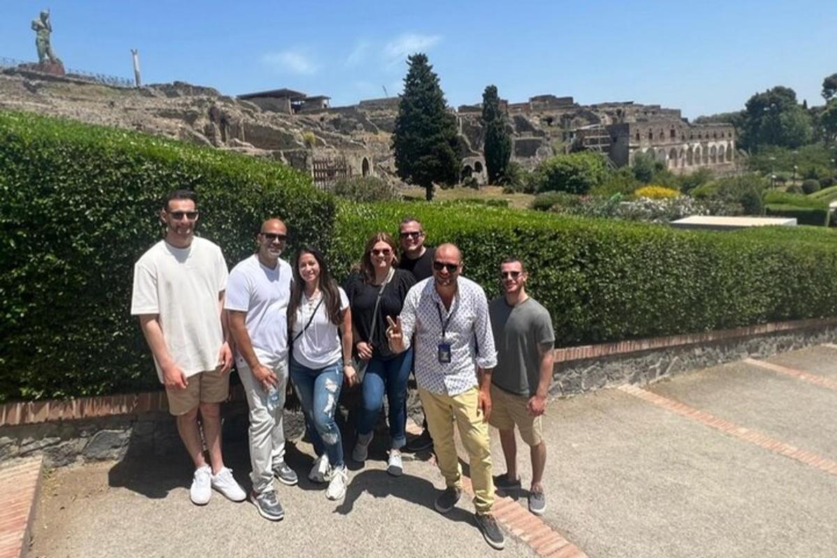un gruppo di persone in posa per una foto davanti a una siepe