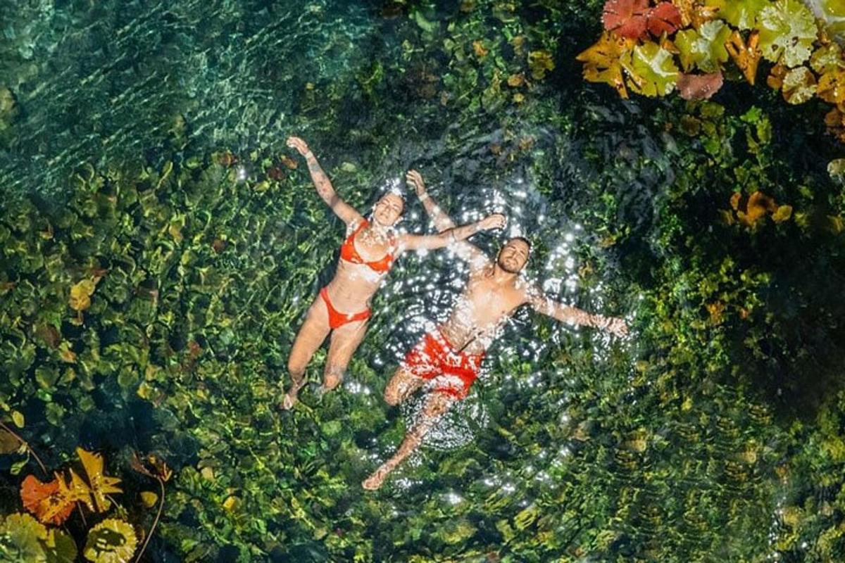 two people laying in the water in a swimming pool