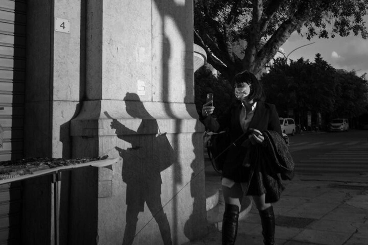 μια γυναίκα που στέκεται δίπλα σε μια σκιά ενός ατόμου