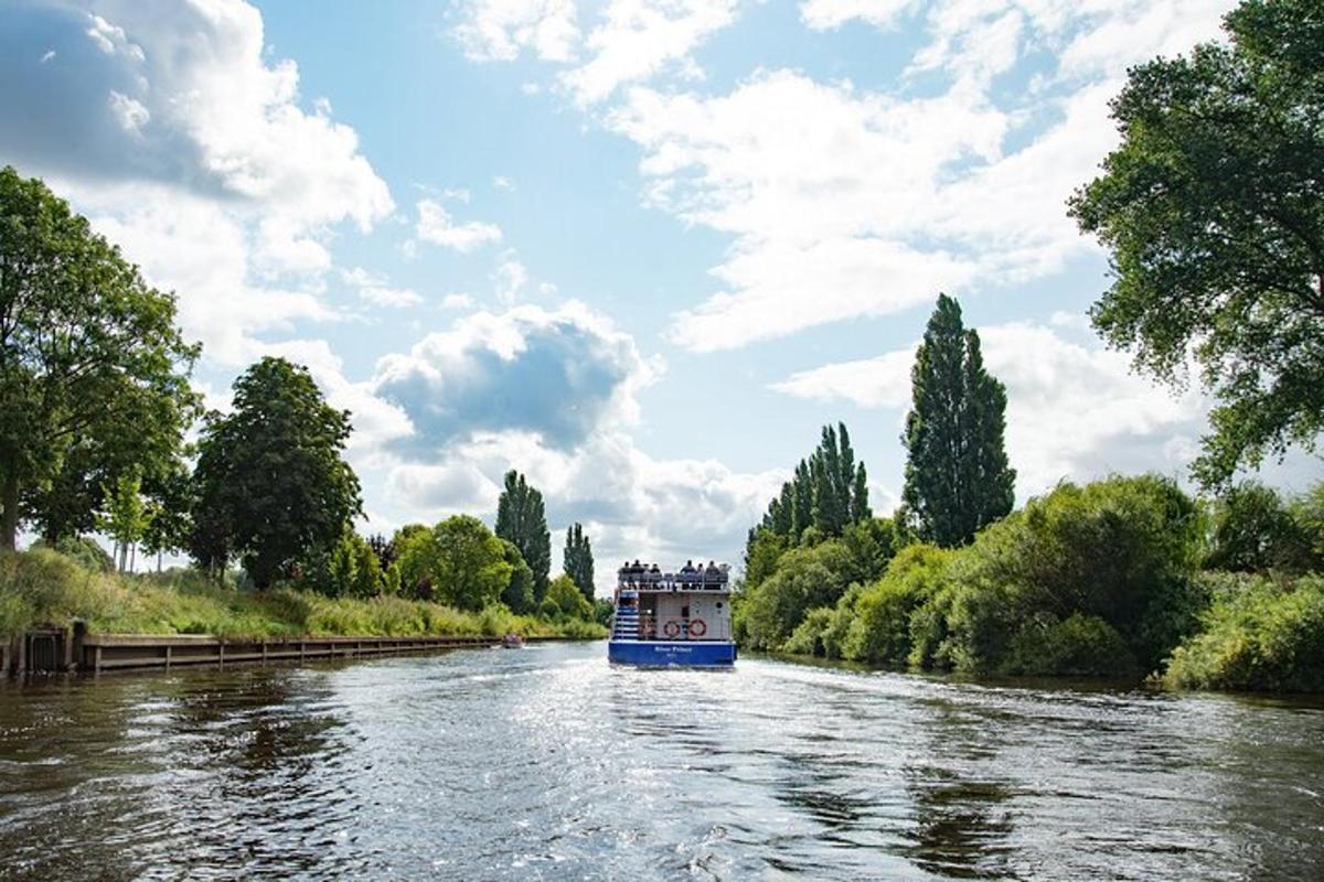 a blue boat traveling down a river with trees