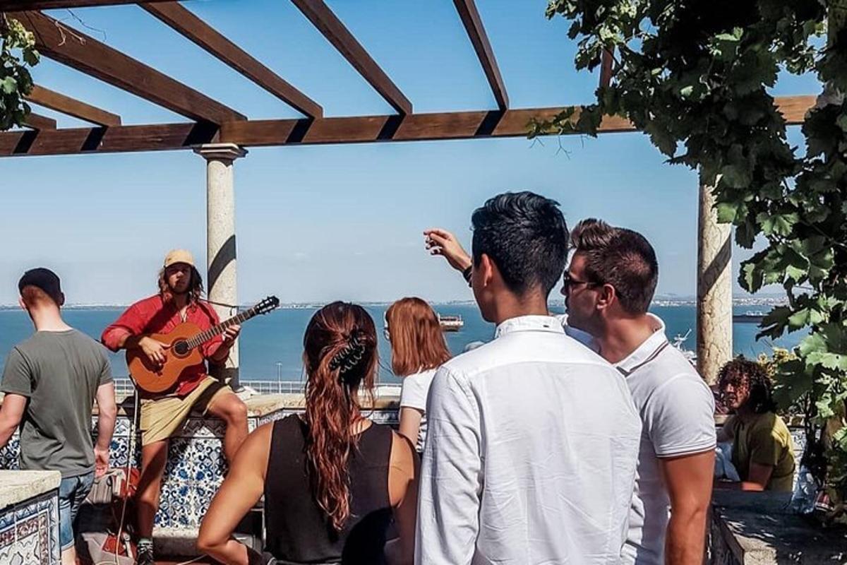 un gruppo di persone che guarda un uomo che suona la chitarra