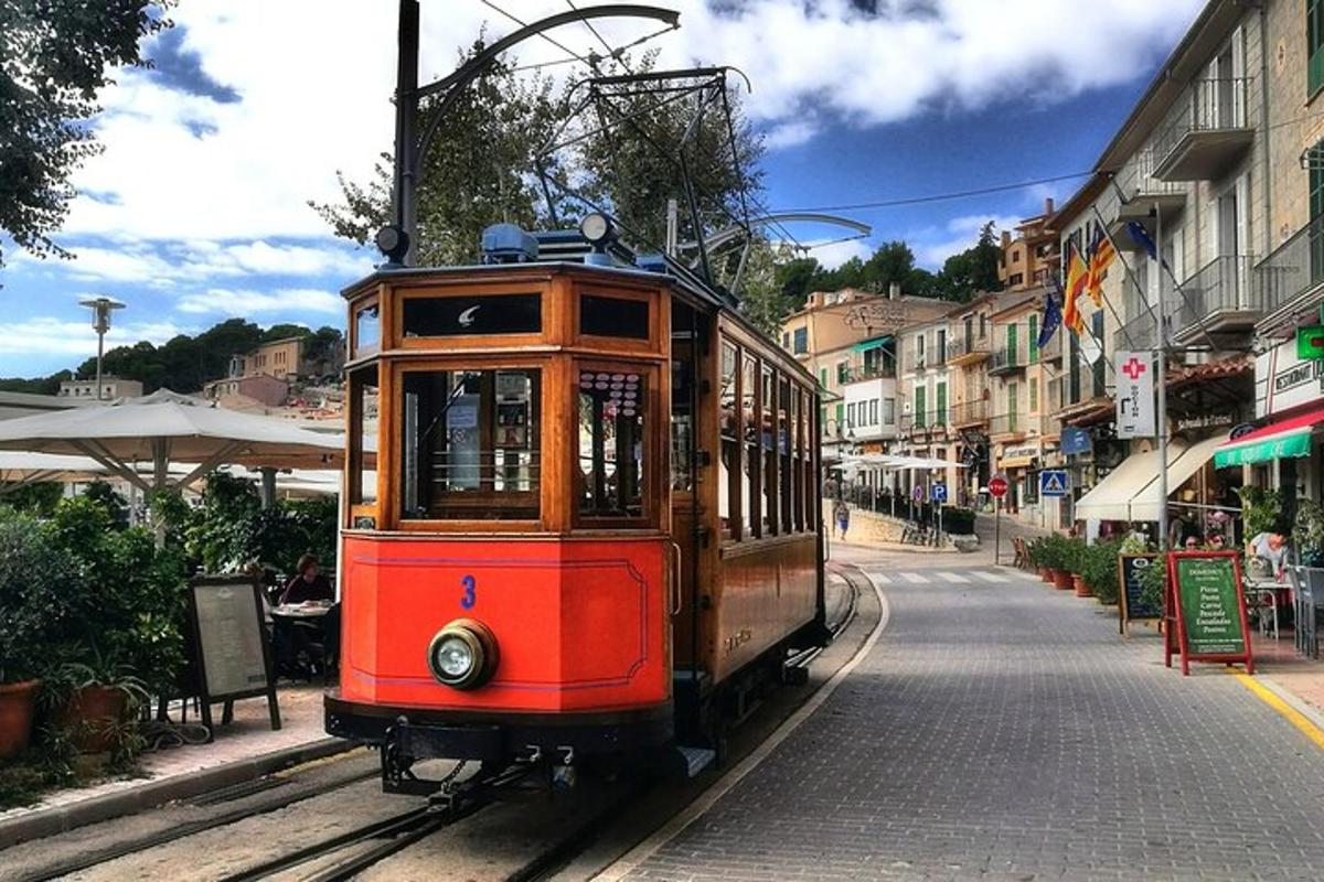 un tramvai roșu pe șinele de pe o stradă