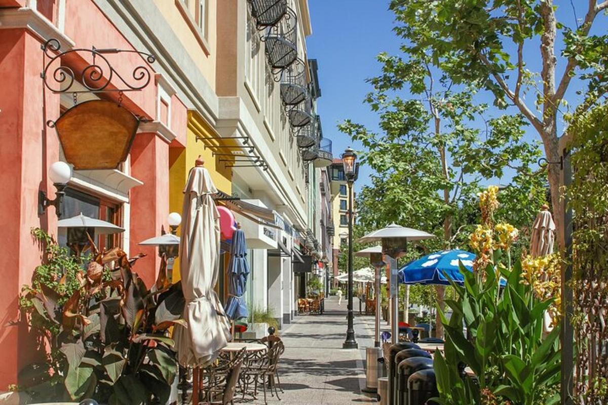 mestská ulica so stolmi, slnečníkmi a stoličkami