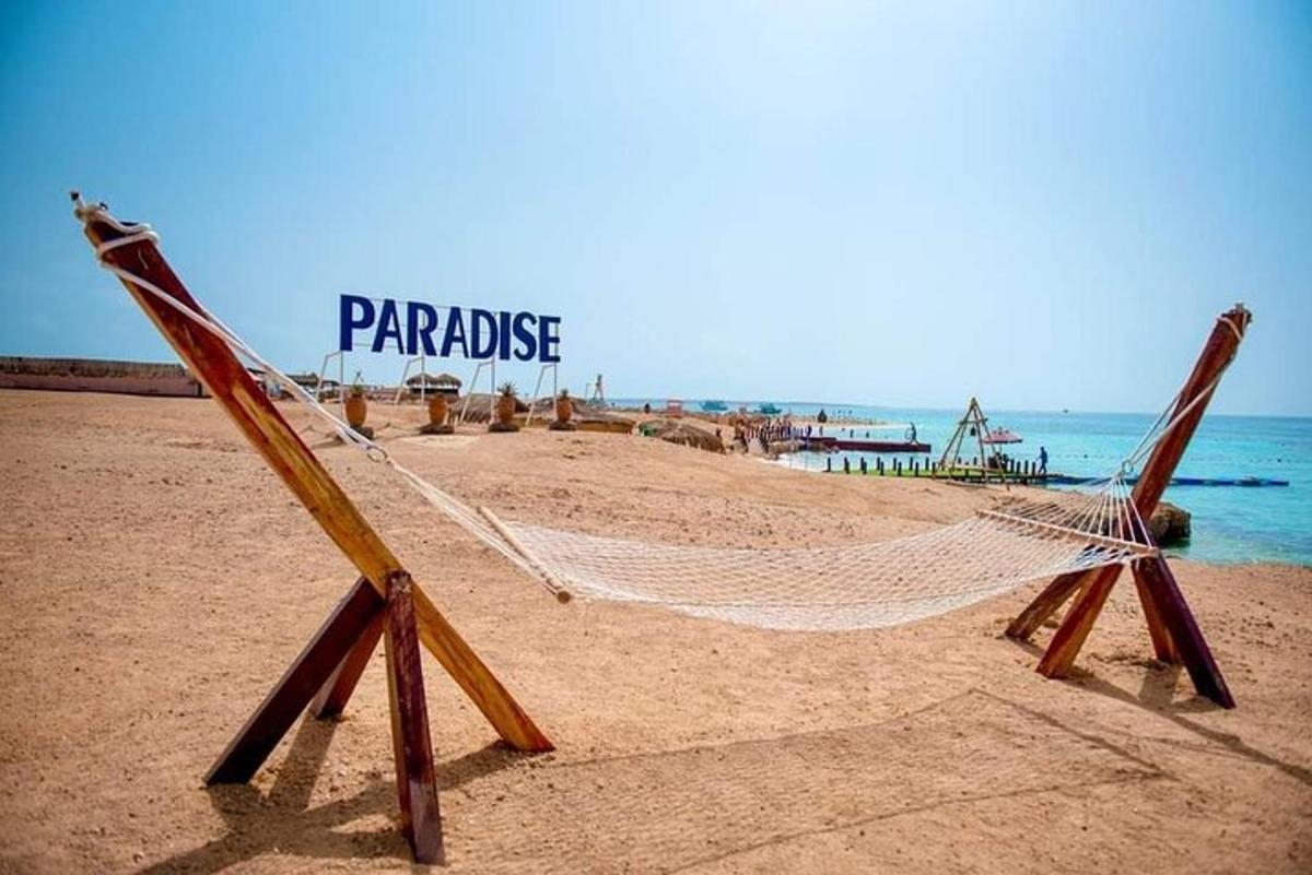 una hamaca a la platja amb les paraules paradís