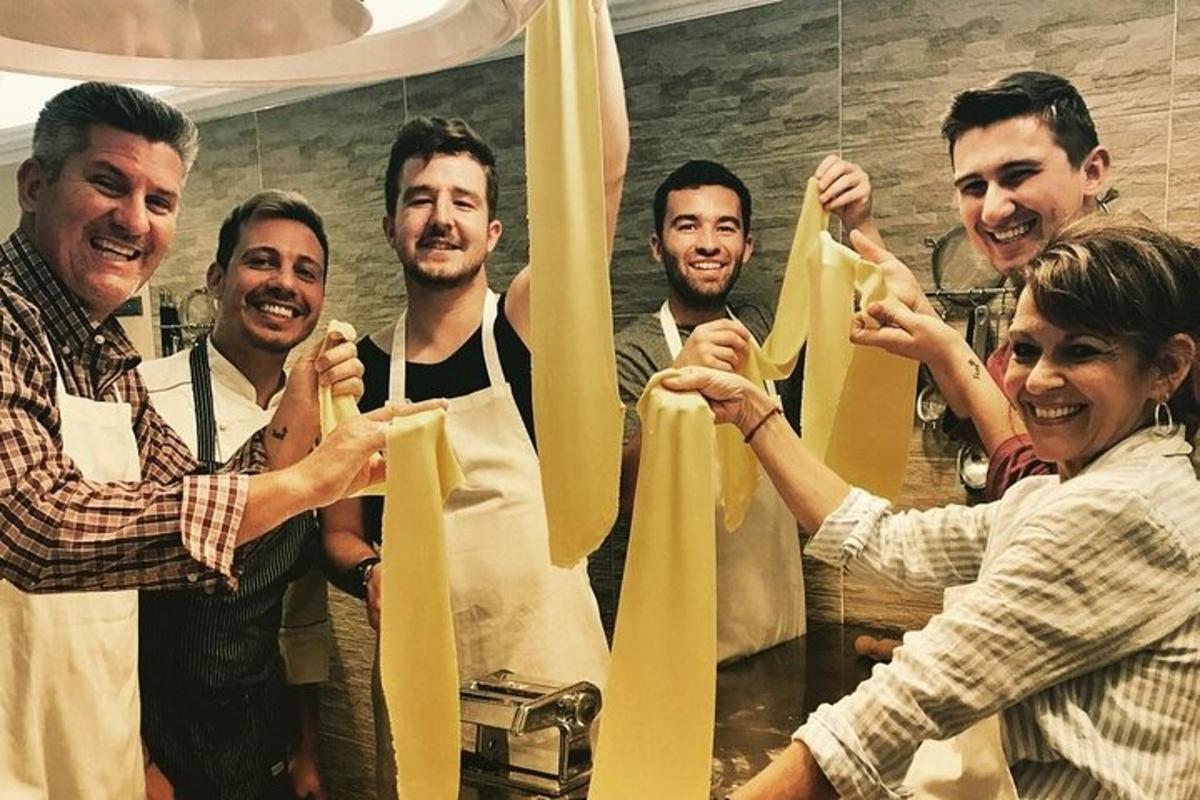 Μια ομάδα ανθρώπων που κρατούν μια κορδέλα σε μια κουζίνα