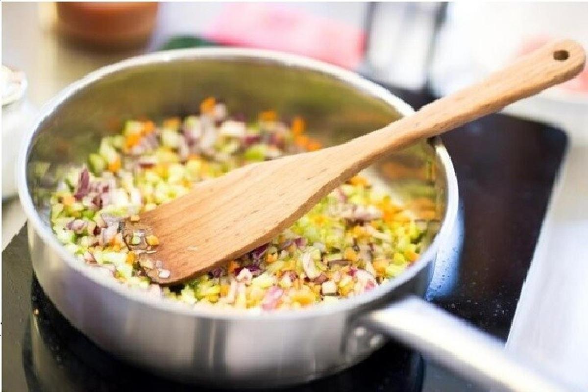 một cái thìa gỗ trong nồi thức ăn trên bếp
