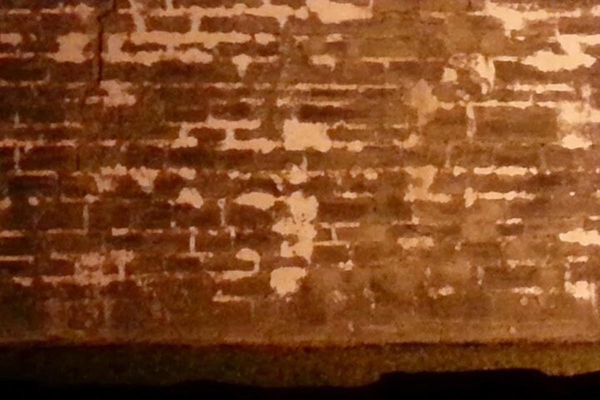 un muro di mattoni con un po' di vernice sopra