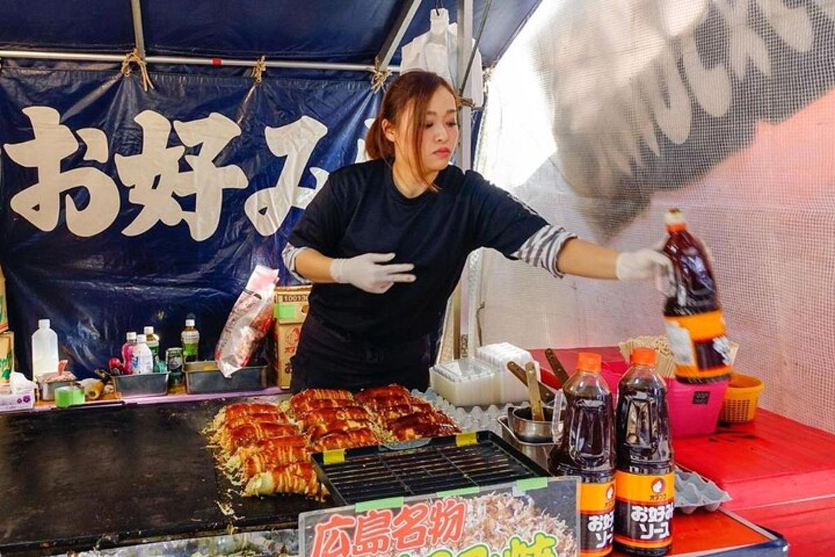 egy nő áll egy grillsütő előtt étellel