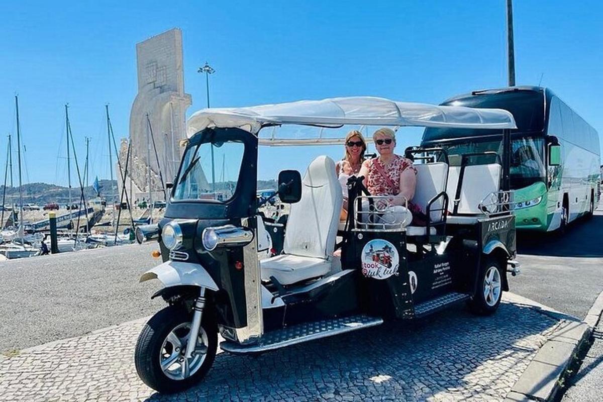 dvi moterys važiuoja golfo vežimėliu su autobusu