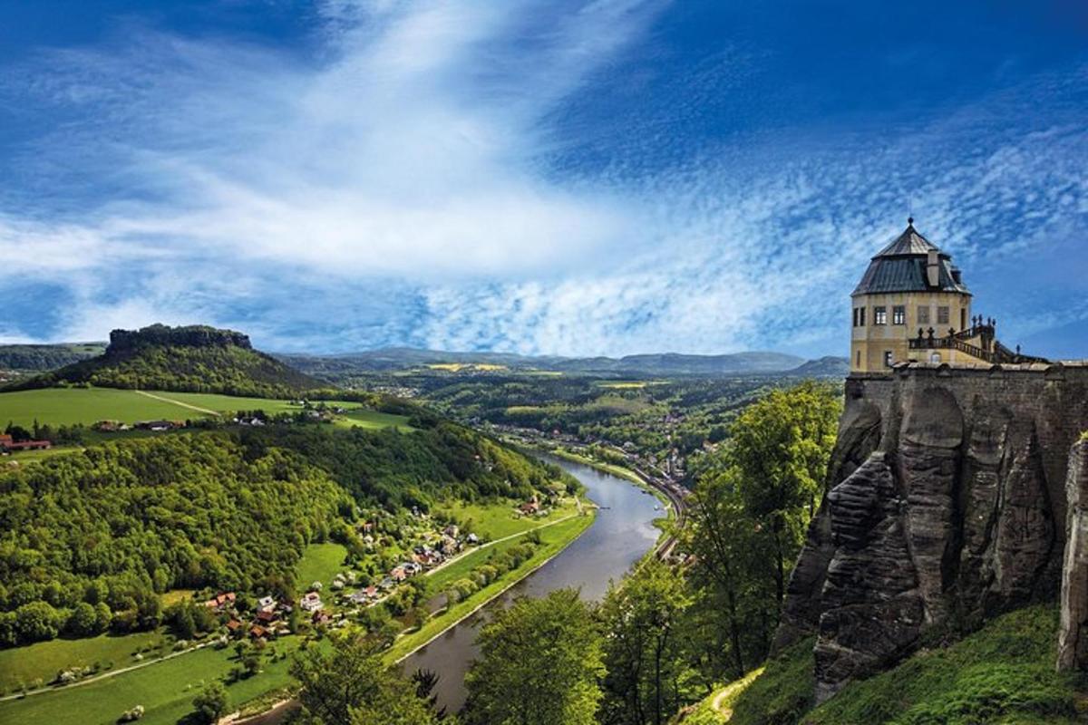 a castle on top of a cliff next to a river