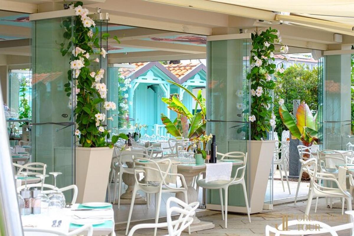 restaurace s bílými židlemi, stoly a rostlinami