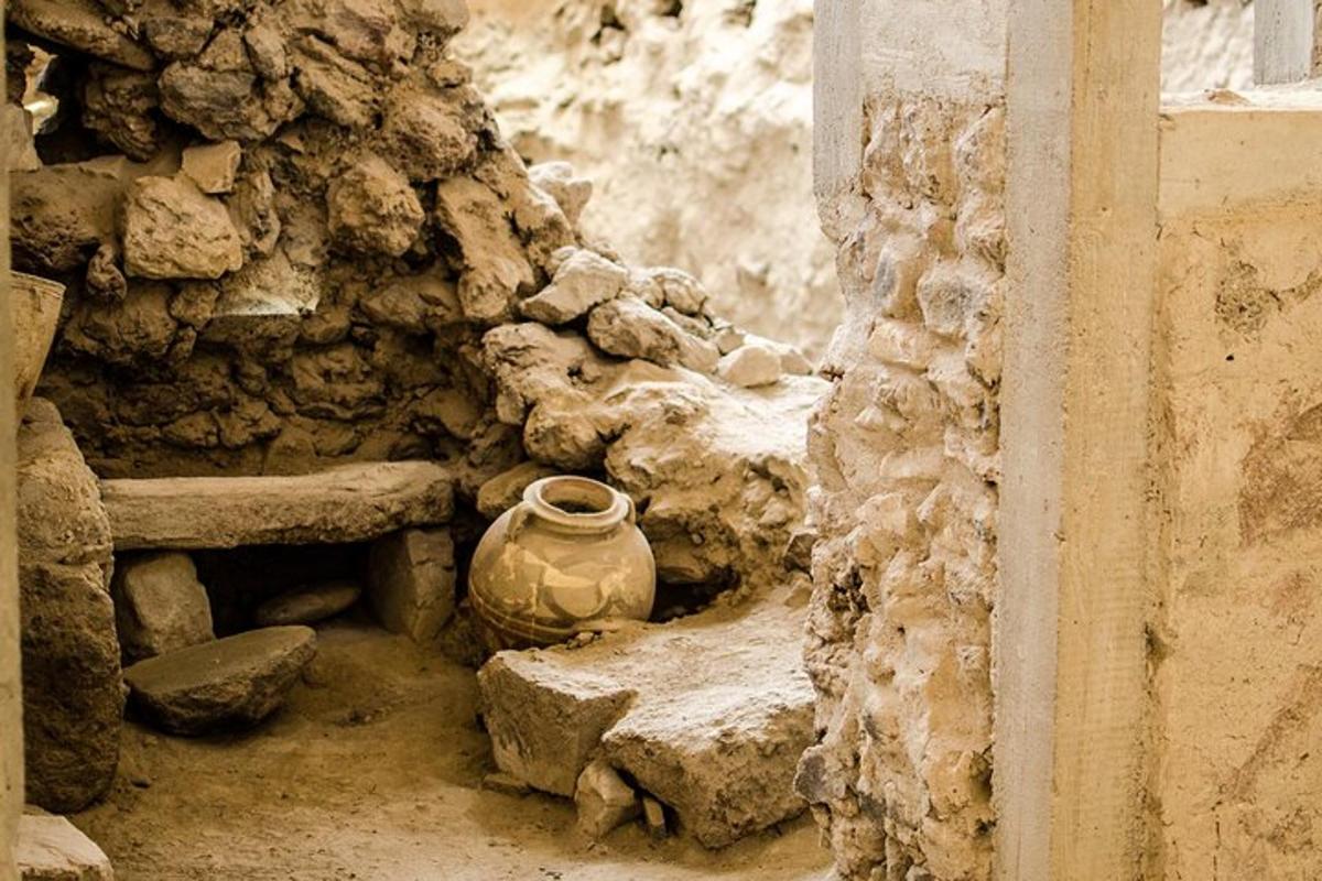 un mur de pedra amb un gerro al costat d'un banc de pedra