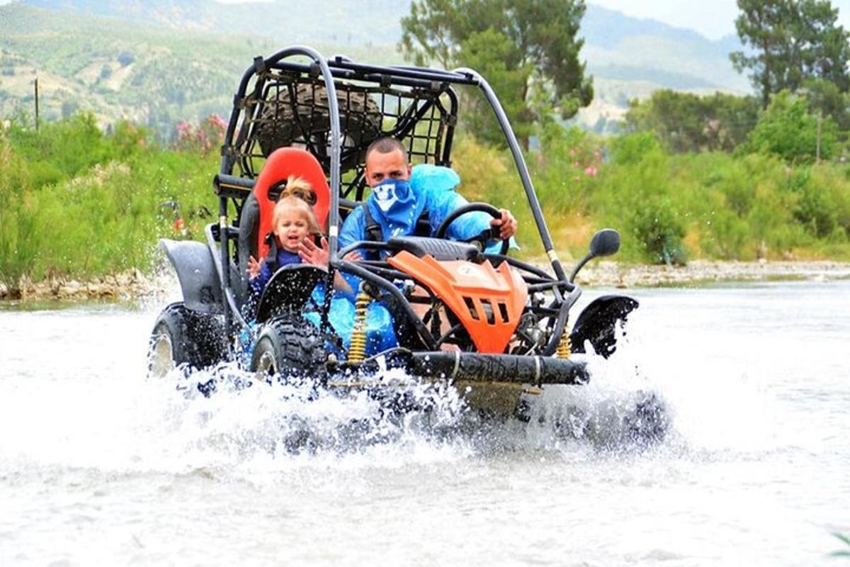 seorang pria dan seorang anak mengendarai ATV di dalam air