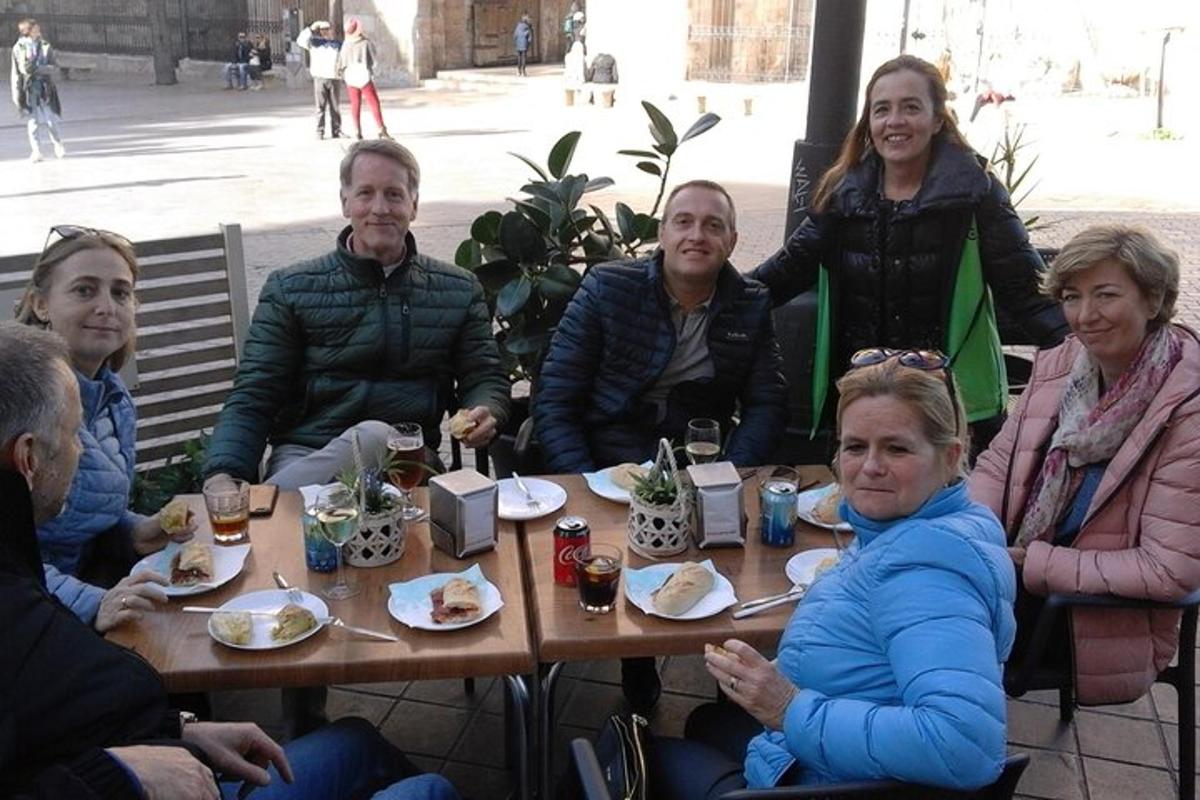 un grup de persones assegudes al voltant d'una taula de fusta