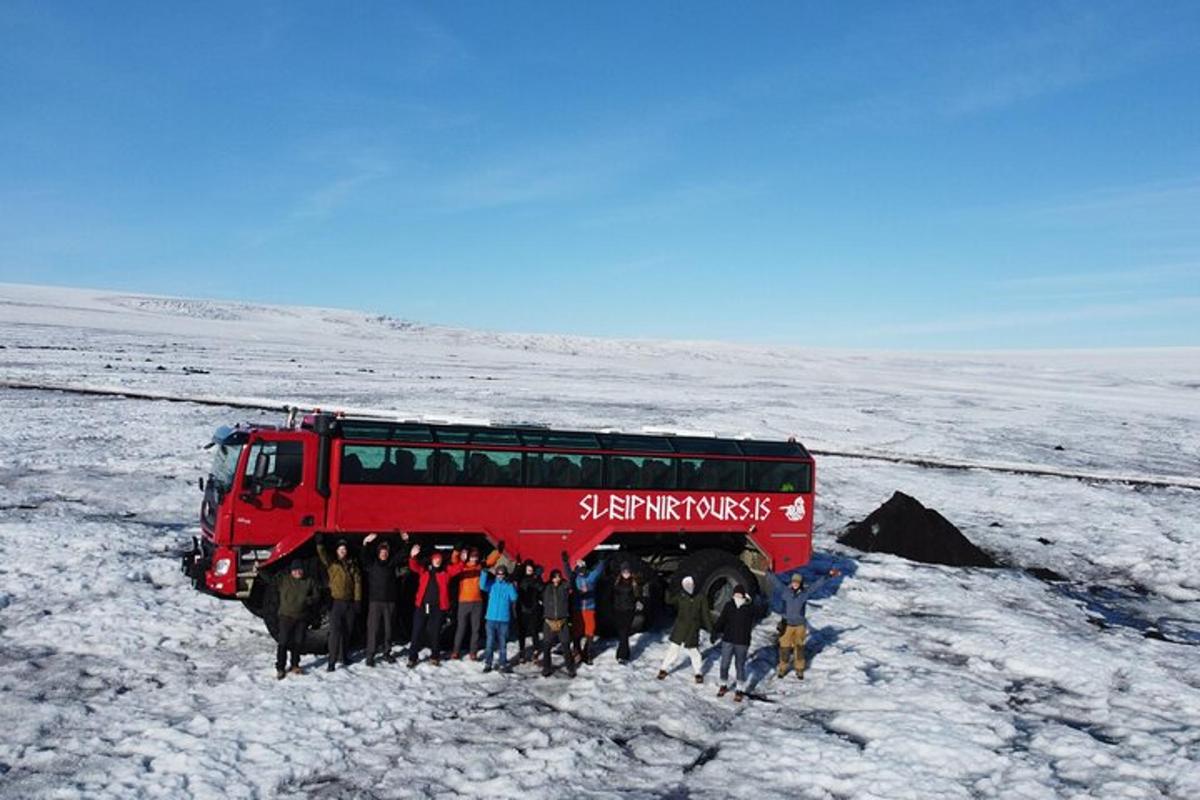 eine Gruppe von Menschen steht vor einem roten Bus