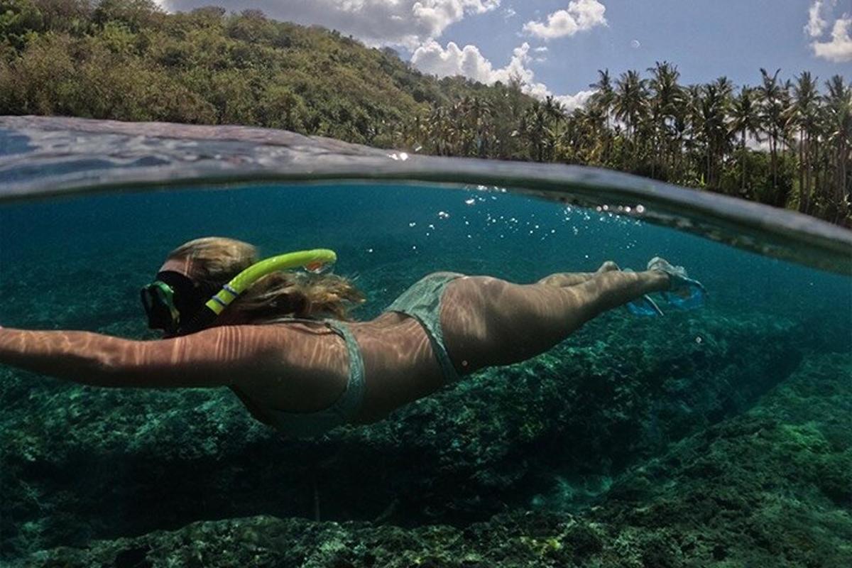 a woman is swimming in the water with a frisbee