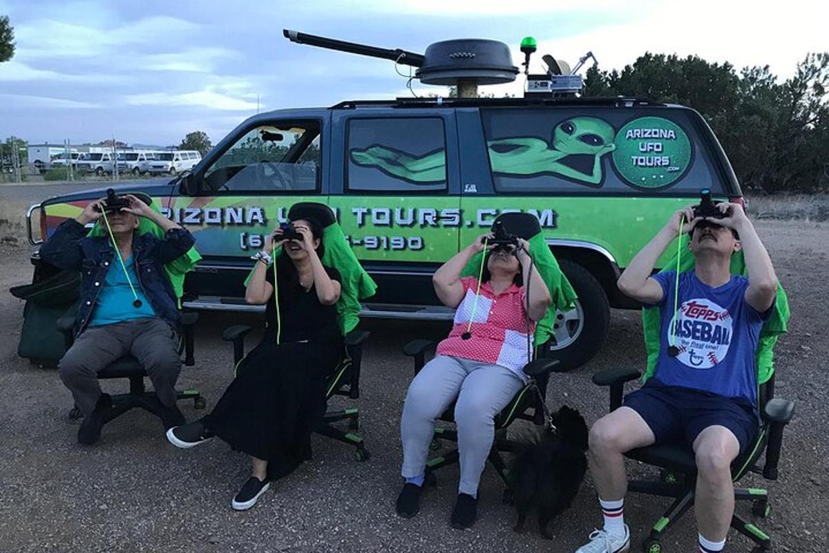 un gruppo di persone che scattano foto davanti a un veicolo