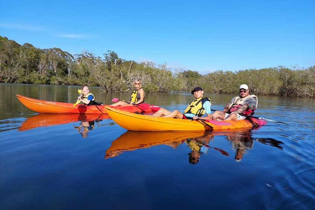 a group of people sitting in kayaks on the water