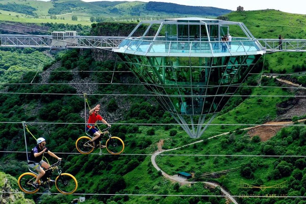 Dos personas montando bicicletas en una tirolina