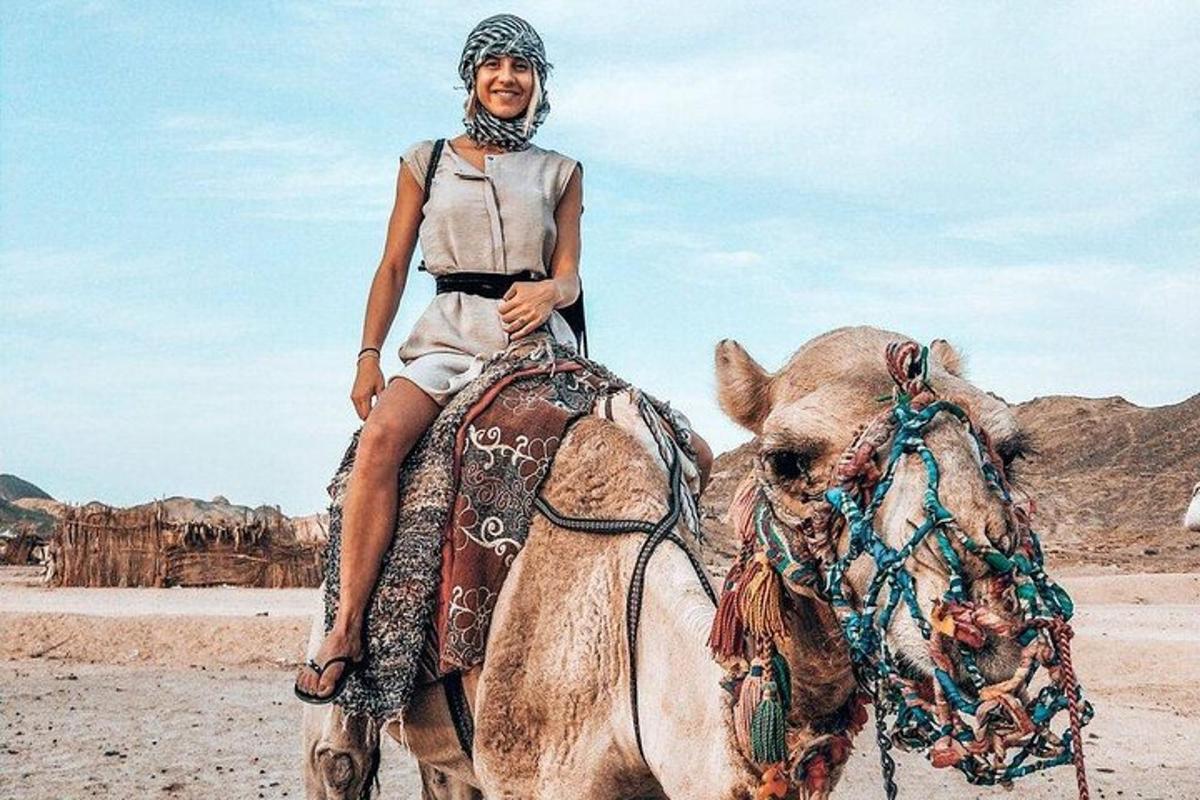 un uomo a cavallo di un cammello nel deserto