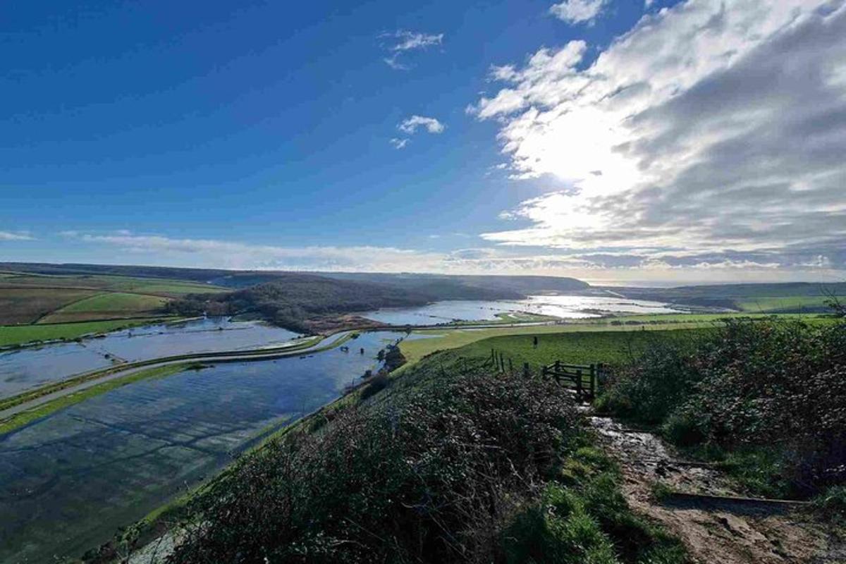 a view of a river from a hill with the sky