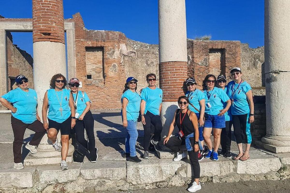 a group of people in blue shirts standing in front of ruins
