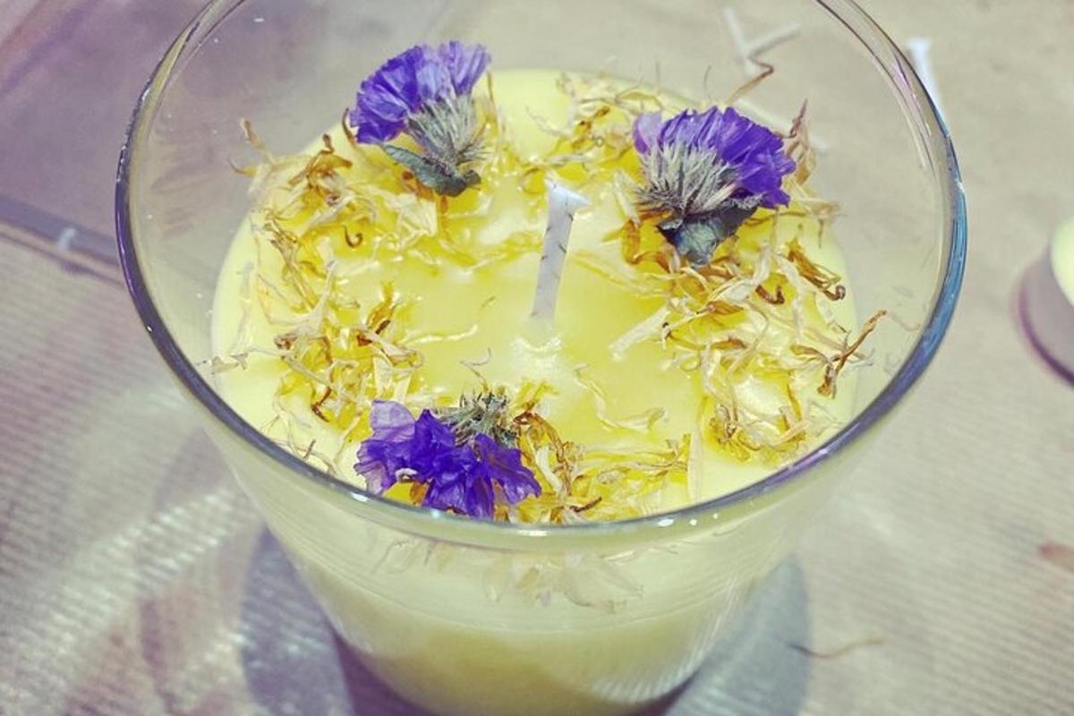 a glass with purple flowers on top of a drink